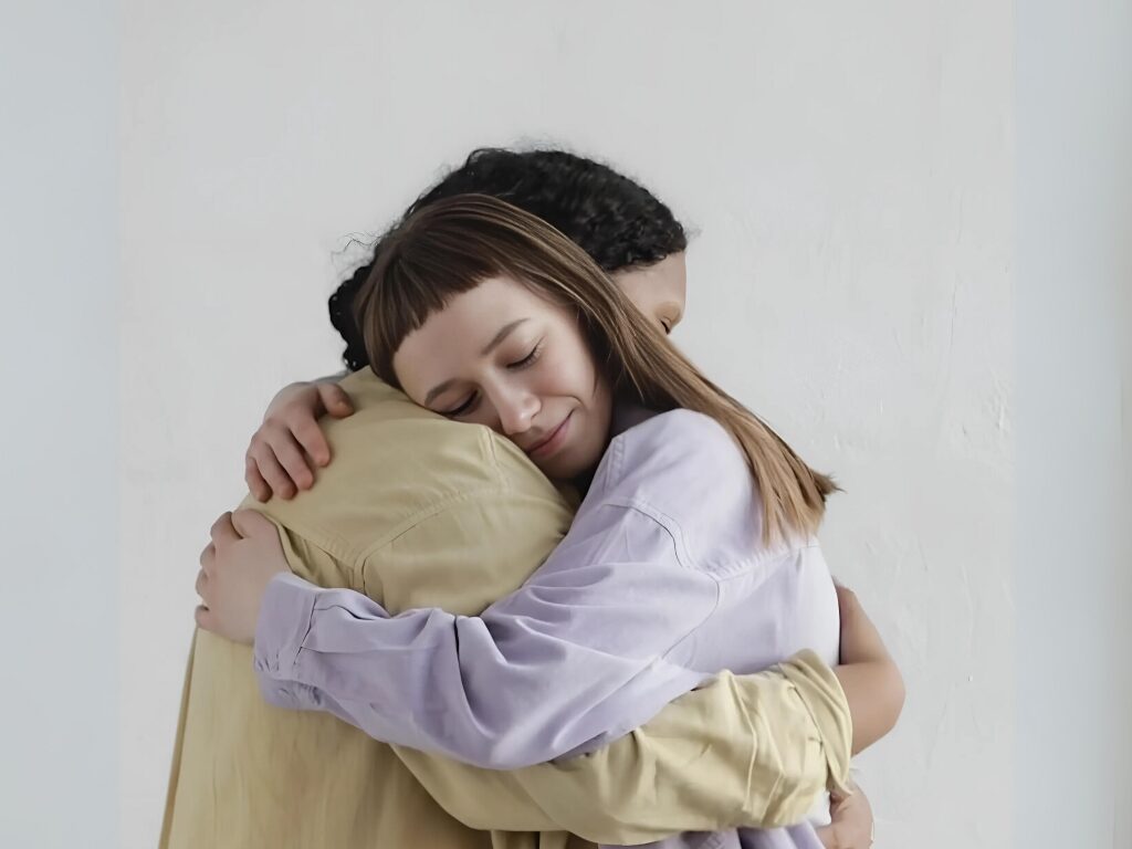 Mentor embracing her mentored youth; in this case, a girl. Image represents the impact mentorship can have at advancing the mission of International Day of the Girl Child.