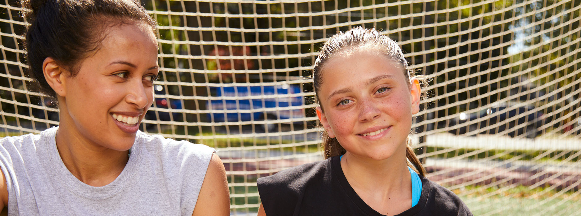 1:1 mentorship program participants sitting on soccer field